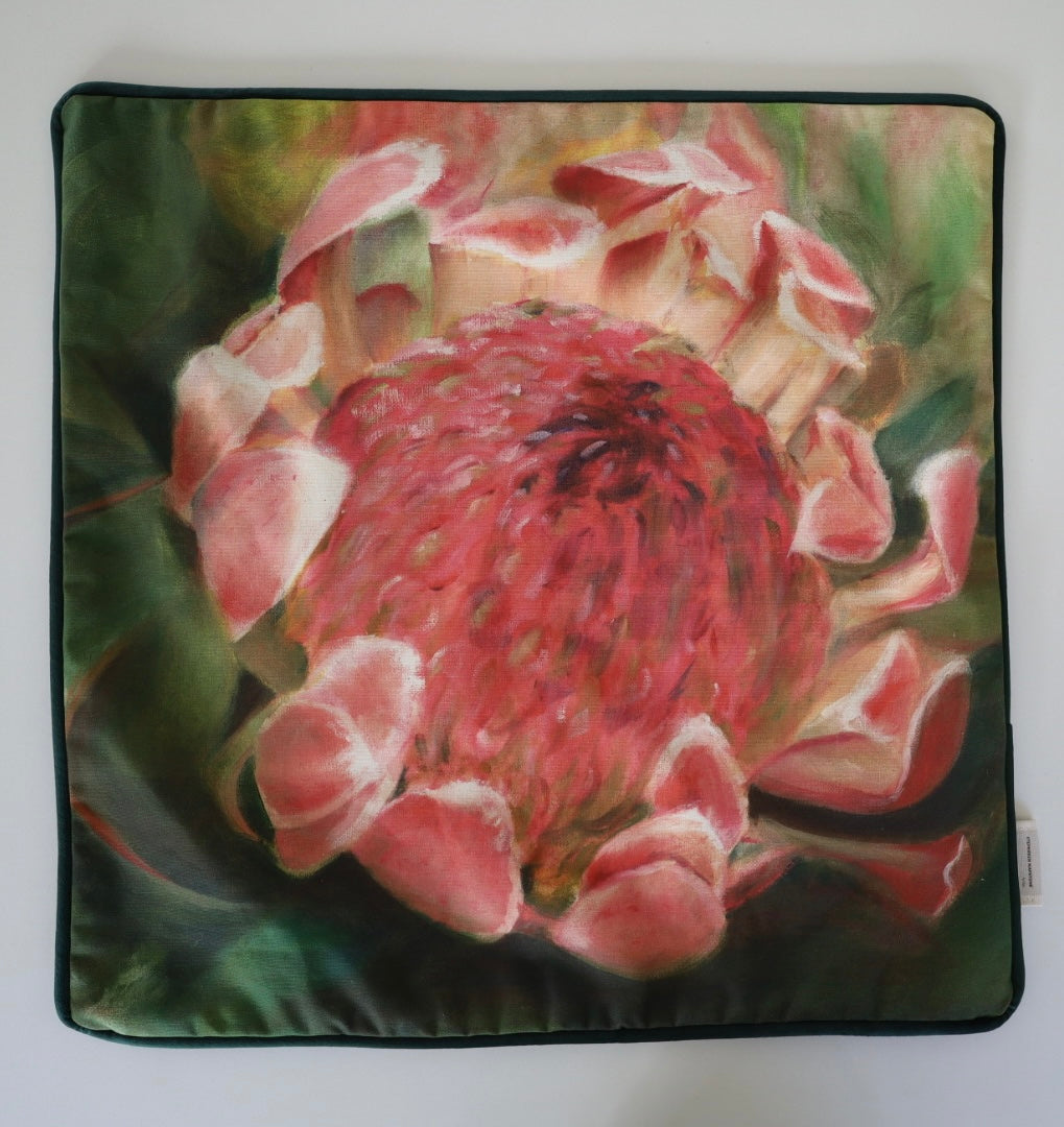 Image shows front of square 60×60 cm cushion cover with pale delicate pink protea with green leaves from oil painting print, velvet piping, velvet back, and concealed zip closure.