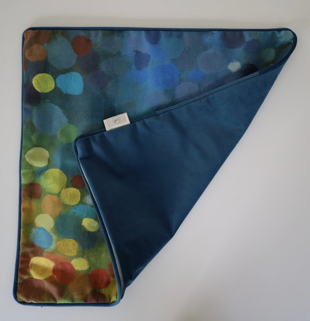 Image shows folded back and front of square 60×60 cm cushion cover with abstract green, yellow, rust and blue oil painting print, velvet piping, velvet back, and concealed zip closure.