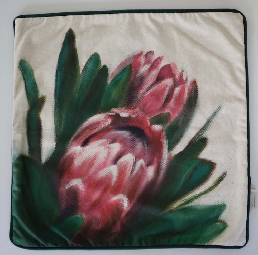 Image shows front of square 60×60 cm cushion cover with pink proteas from oil painting print, velvet piping, velvet back, and concealed zip closure.